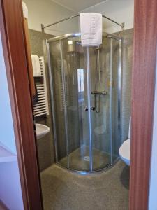 a shower with a glass door in a bathroom at Gauksmýri guesthouse in Hvammstangi