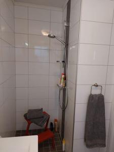 uma casa de banho com um chuveiro com uma toalha e um banco em Rorbu i Austevoll med 3 soverom og mulighet for båtleie em Kolbeinsvik