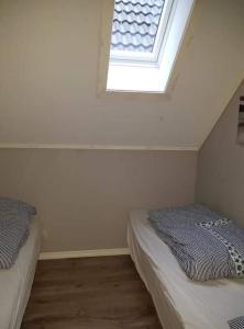 um quarto no sótão com 2 camas e uma janela em Rorbu i Austevoll med 3 soverom og mulighet for båtleie em Kolbeinsvik