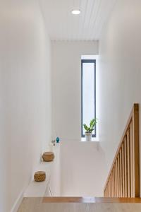 a white room with a staircase and a window at AGUIAR´S VILLAGE in Ribeira Brava