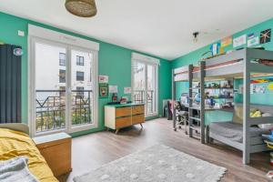 1 dormitorio con paredes verdes y literas en Maison duplex avec jardin, en Saint-Ouen