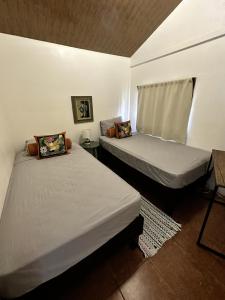 2 camas en una habitación pequeña con ventana en Casa Morpho Uvita Guesthouse, en Uvita