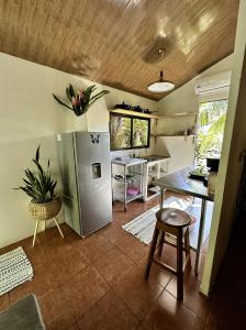 a kitchen with a table and a refrigerator at Casa Morpho Uvita Guesthouse in Uvita