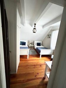 Cette chambre mansardée comprend deux lits et un couloir. dans l'établissement Wałpusz Holiday Home, à Szczytno