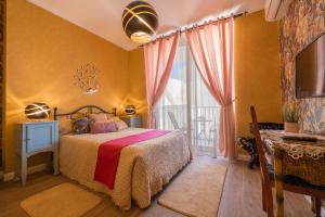 a bedroom with a bed and a large window at Encanto Townhouse Sliema in Sliema