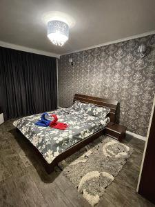 una camera da letto con un letto con un oggetto blu e rosso sopra di Cozy studio tiglina a Galaţi