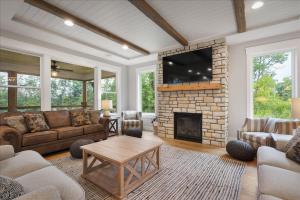 sala de estar con sofá y chimenea en New! Northwoods Luxury - 5 Pines On Trout Lake, en Pine River