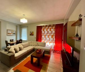 uma sala de estar com um sofá e uma mesa em Downtown Apartment em Korçë
