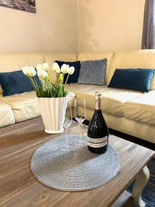 a bottle of wine and two glasses on a coffee table at Wałpusz Holiday Home in Szczytno