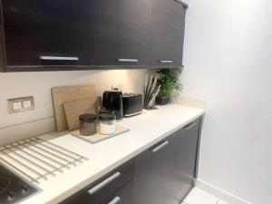 cocina con armarios negros y encimera blanca en Free Parking 1 bedroom flat with double Sofa Bed, en Mánchester