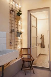 a wooden chair in a bathroom with a mirror at B/Loft in Prato
