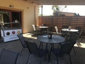 un patio con mesas, sillas y una parrilla en Apartmán 1 Fklidu, en Znojmo 4 fotos más
