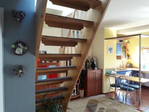 a wooden spiral staircase in a kitchen with a table at Apartament z Widokiem na Morze w Kołobrzegu in Kołobrzeg
