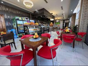 restauracja z czerwonymi krzesłami i stołami w sklepie w obiekcie Hôtel Lina w mieście Bordj Bou Arreridj