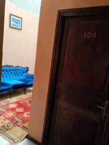 eine Tür, die zu einem Zimmer mit einem blauen Sofa führt in der Unterkunft Hotel Des voyageur in Ouarzazate