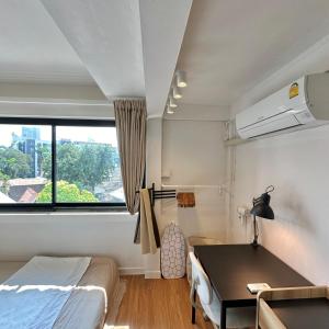 - une chambre avec un lit, un bureau et une fenêtre dans l'établissement Room 580m bts Prompong, à Klong Toi