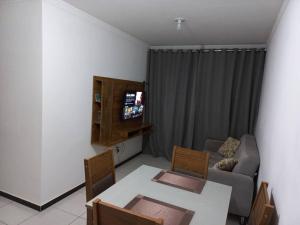 ein Wohnzimmer mit einem Tisch und einem Sofa in der Unterkunft Apartamento 2 quartos na área central perto do GV Shopping in Governador Valadares