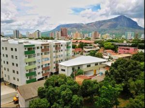 eine Stadt mit Gebäuden und einem Berg im Hintergrund in der Unterkunft Apartamento 2 quartos na área central perto do GV Shopping in Governador Valadares