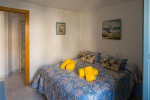 a bedroom with a bed with yellow pillows at Casa Asia in Granada