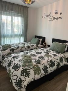 a bedroom with two beds and a sign on the wall at Residence Bali app. 1024 Punta Prima, Casa Kef in Torrevieja