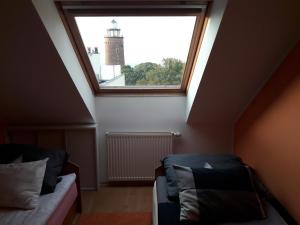 a attic room with a window and a couch at Apartament z Widokiem na Morze w Kołobrzegu in Kołobrzeg