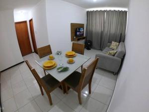 ein Wohnzimmer mit einem Tisch, Stühlen und einem Sofa in der Unterkunft Apartamento 2 quartos na área central perto do GV Shopping in Governador Valadares