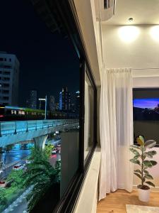 Habitación con ventana y vistas a un puente. en Room 580m bts Prompong en Klong Toi