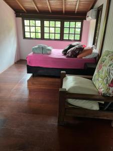 two beds in a room with a woman laying on them at Casa próxima ao mar, Camburi. in São Sebastião