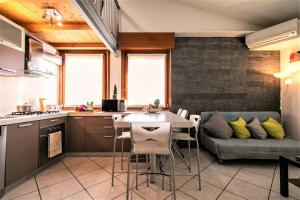 a kitchen and living room with a table and a couch at Casa Mia ,APT WiFi e Parcheggio nel cuore del Friuli in Osoppo