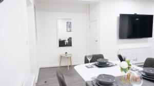a dining room with a table and chairs and a tv at 3-Bedroom Semi near Etihad Football Stadium, Tourist attractions, Manchester City Centre and Transport Links - Sky n Netflix in Manchester
