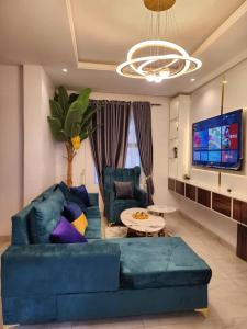 uma sala de estar com um sofá azul e uma televisão em City View Apartments em Lekki