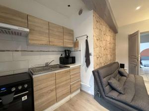 a small kitchen with a couch next to a sink at Le Mirror- hyper centre ville in Sens