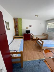 Habitación pequeña con 2 camas y escritorio. en Mimoza JD, en Inđija