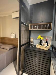 1 dormitorio con 1 cama y vestidor con botellas de vino en Um lugar de charme e aconchego! en Brasilia