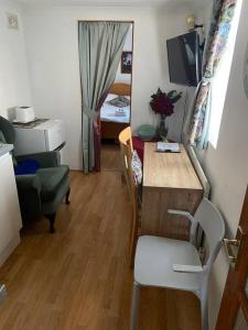 um pequeno quarto com uma secretária e um quarto com um quarto em Private, homely, 1 bedroom apartment SW London. em Hanworth