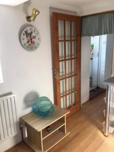 um quarto com um relógio na parede e uma mesa em Private, homely, 1 bedroom apartment SW London. em Hanworth