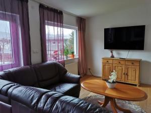 a living room with a leather couch and a table at Apartments in Biedenkopf in Biedenkopf