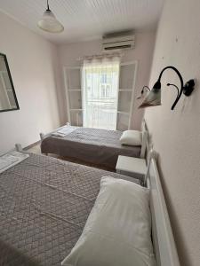 a bedroom with two beds and a window at Alexandros Studios Apartments in Roda