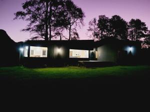 una casa iluminada por la noche con luces en Casa de campo sobre el rio, en llifen