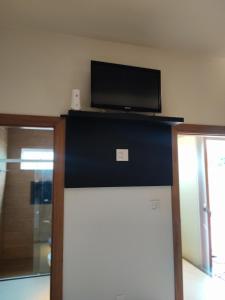 a room with a tv on top of a wall at Suíte Alto Padrão in Uberaba