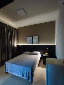 - une chambre avec un lit doté d'un couvre-lit bleu dans l'établissement Suíte Alto Padrão, à Uberaba