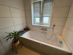 a bathroom with a tub and a plant in it at Fewo BOHO mit eigenem Garten nähe Salzburg in Freilassing