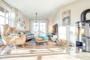 a living room with a couch and a fireplace at Ferienhaus Haubenlerche 27 in Fuhlendorf