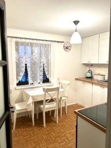 a kitchen with a white table and chairs and a window at Wałpusz Holiday Home in Szczytno