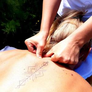una mujer recibiendo un masaje de espalda con la palabra relajarse en su espalda en Maison d'hôte de l'Aber - Sable en Crozon