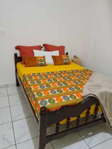a bed with a colorful blanket on top of it at LE COROSSOL APPART in Mamoudzou
