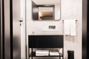 uma casa de banho com um lavatório e um espelho em The Londoner Hotel St. Julian's em St. Julian's