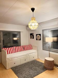 Sofá en habitación con lámpara y ventanas en Vaasa homestay, en Vaasa