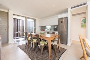 a kitchen and dining room with a wooden table and chairs at Luxurious Ocean Dune Unit in Umhlanga