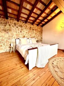 a bedroom with a bed and a stone wall at B&B La Vista Brava in Platja  d'Aro